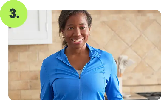 Smiling woman in a kitchen representing successful Nutrisystem weight loss results.