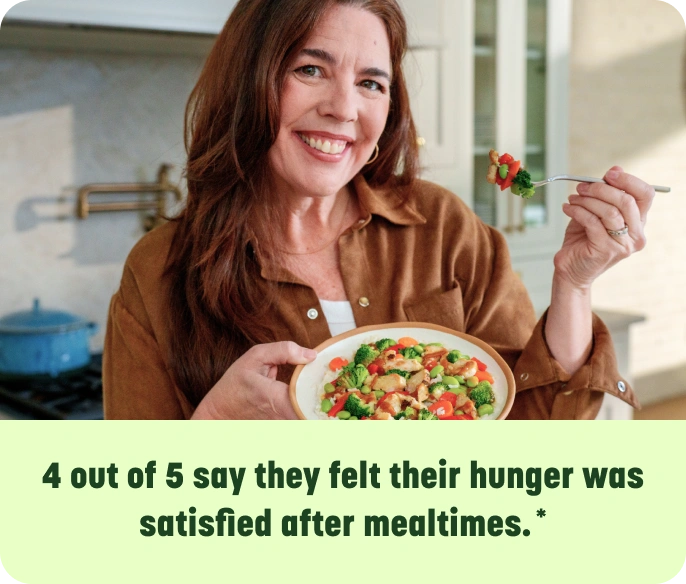 Laura holding chicken and vegeteables dish - 4 out of 5 say they felt their hunger was satisfied after mealtimes.**